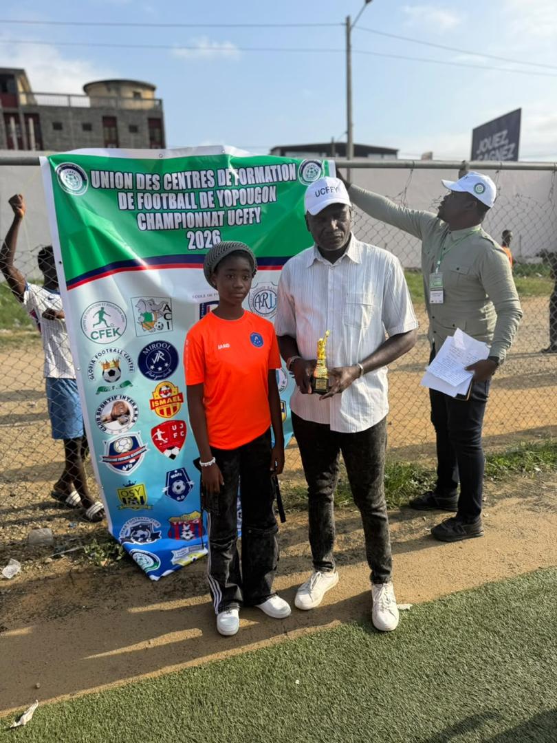 Remise d'un trophée à un joueur de JR MIROOL CI devant la banderole du Championnat UCFFY 2026