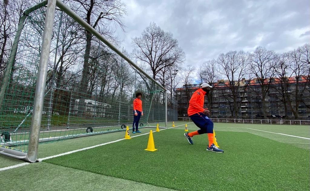 Coach expliquant un exercice de vitesse aux joueurs entre les plots