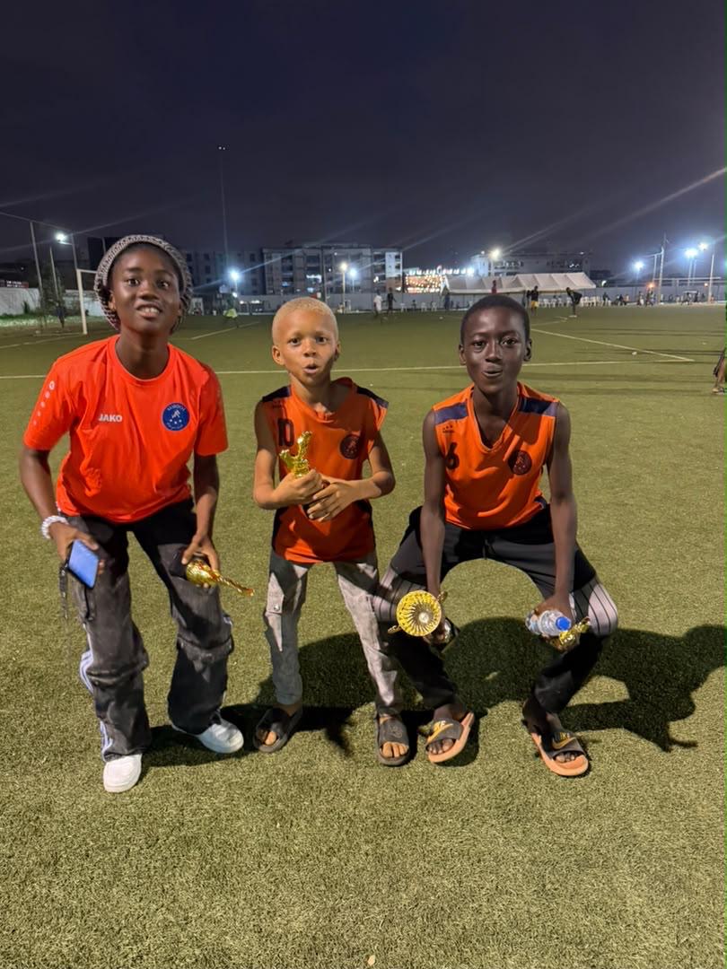 Trois jeunes joueurs de JR MIROOL CI posant avec leurs trophées après le tournoi