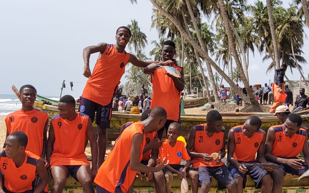 Joueurs assis sur une pirogue lors d'une sortie au bord de la mer